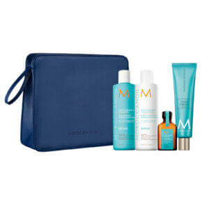 Moroccanoil Moisture Repair Gift Set 2023 showing contents of Moisture Repair Shampoo and Conditioner, Original treatment oil mini and Hand Cream all in a blue wash/travel bag