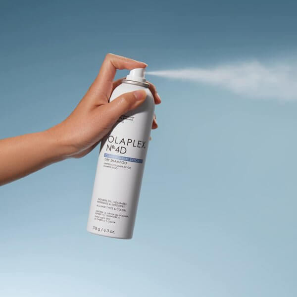 Olaplex No 4D Clean Volume Detox Dry Shampoo aerosol being sprayed into the air